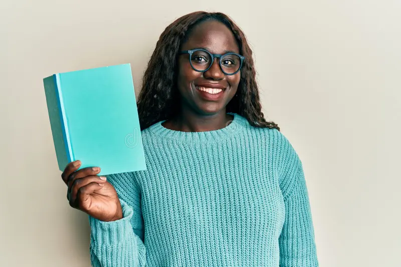 african-young-woman-reading-book-wearing-glasses-looking-positive-happy-standing-smiling-confident-smile-showing-215131444