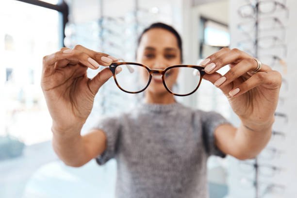 Shot of a young woman buying a new pair of glasses at an optometrist store